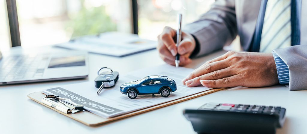 Image of a customer signing on car financing documents