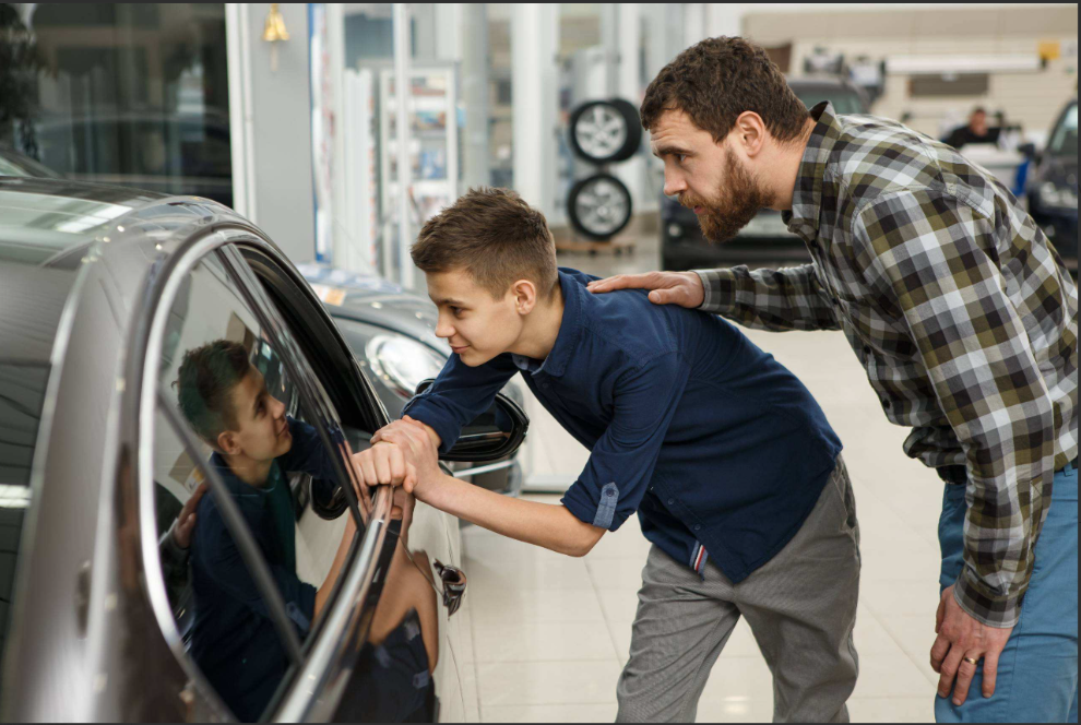 Customers inspecting a vehicle inside a dealership showroom.